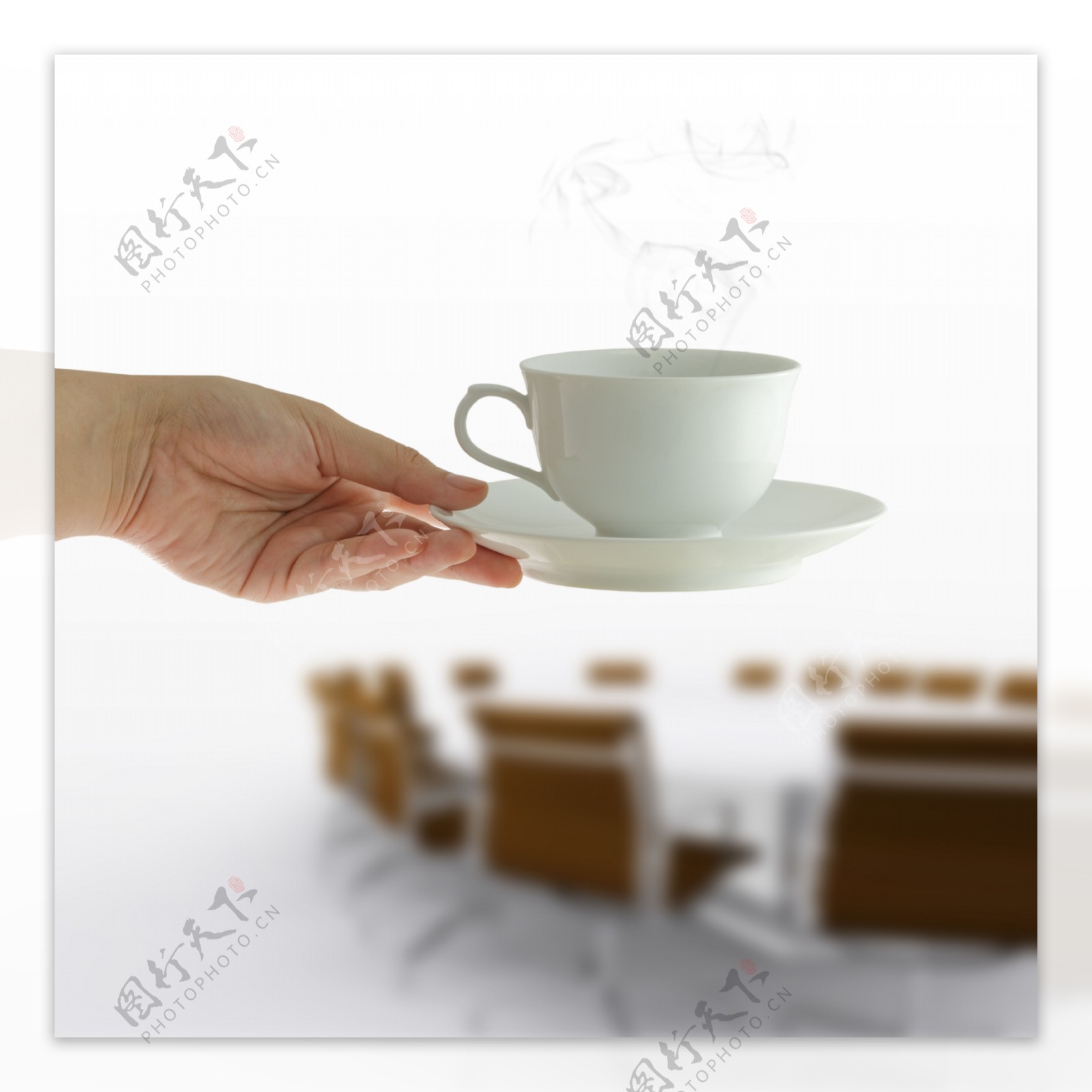 在女人手中的咖啡杯在会议桌的背景