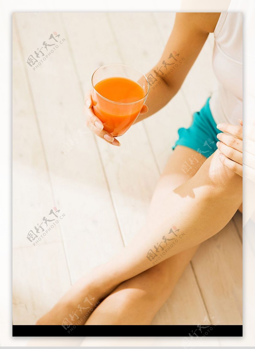 坐在地板上喝果汁的美女图片