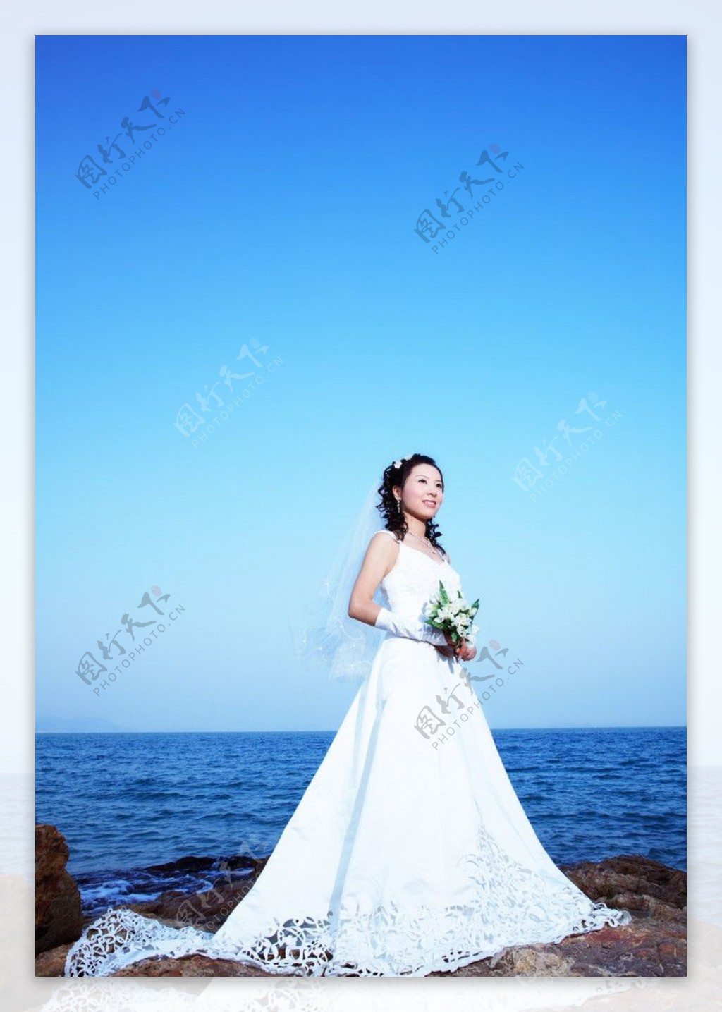 大海边手捧鲜花的新娘图片