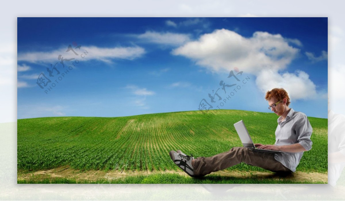 蓝天白云绿野下笔记本上网工作的帅哥图片