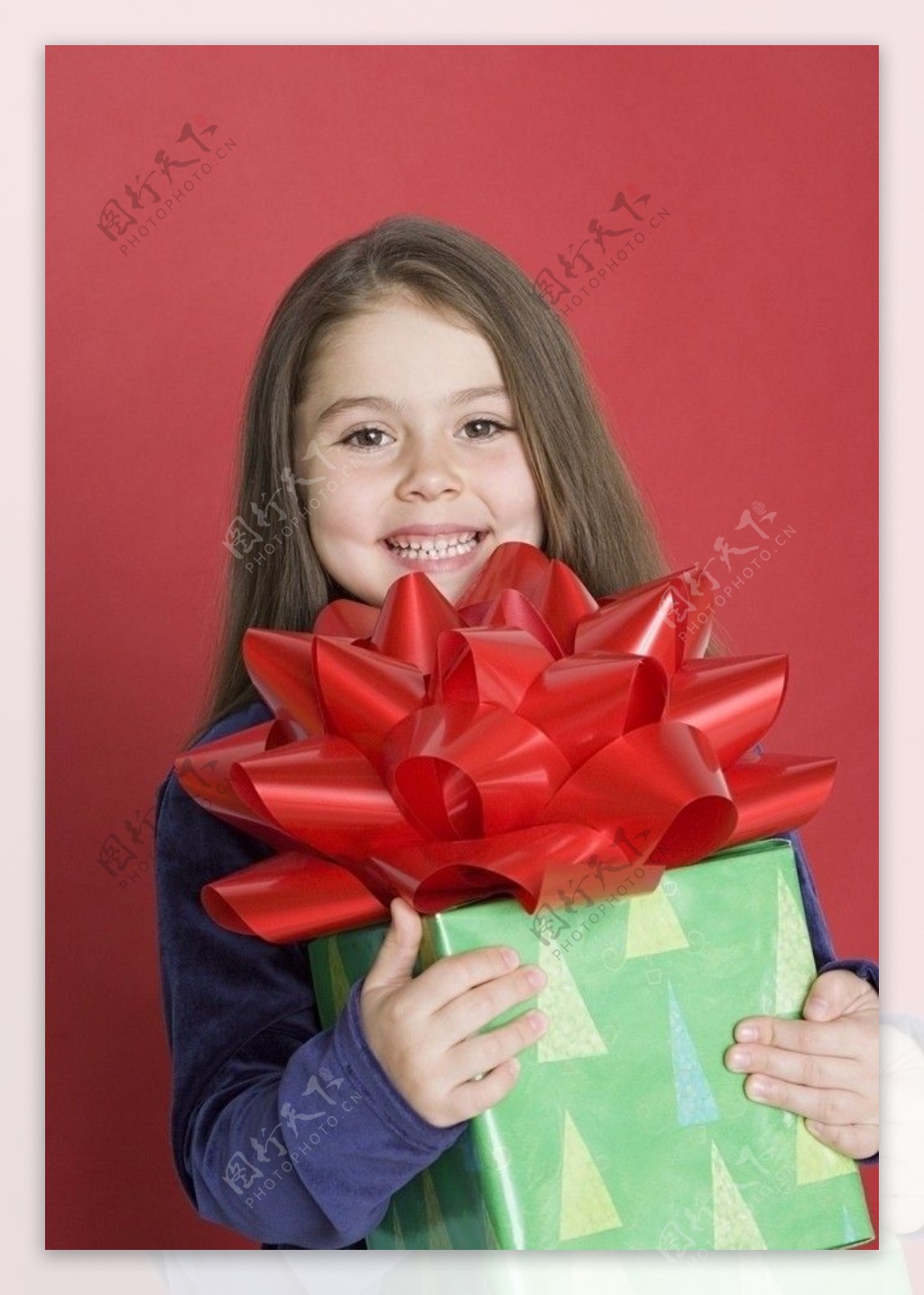 抱着礼品盒的微笑小女孩图片