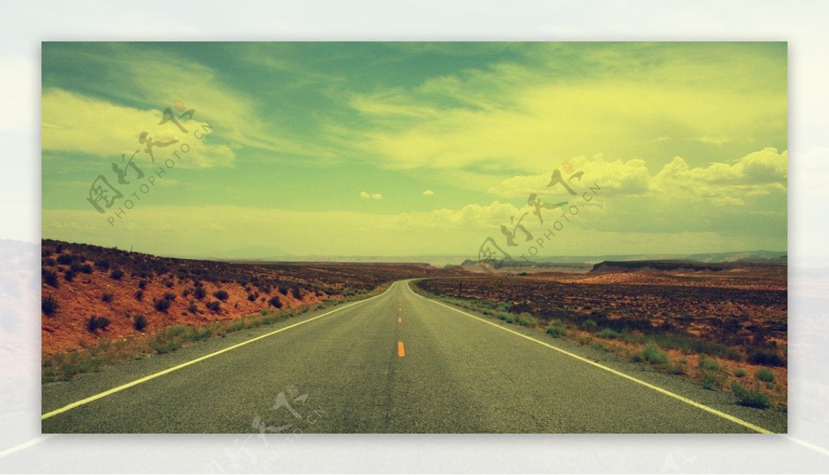 绿色天空下沙漠里的公路