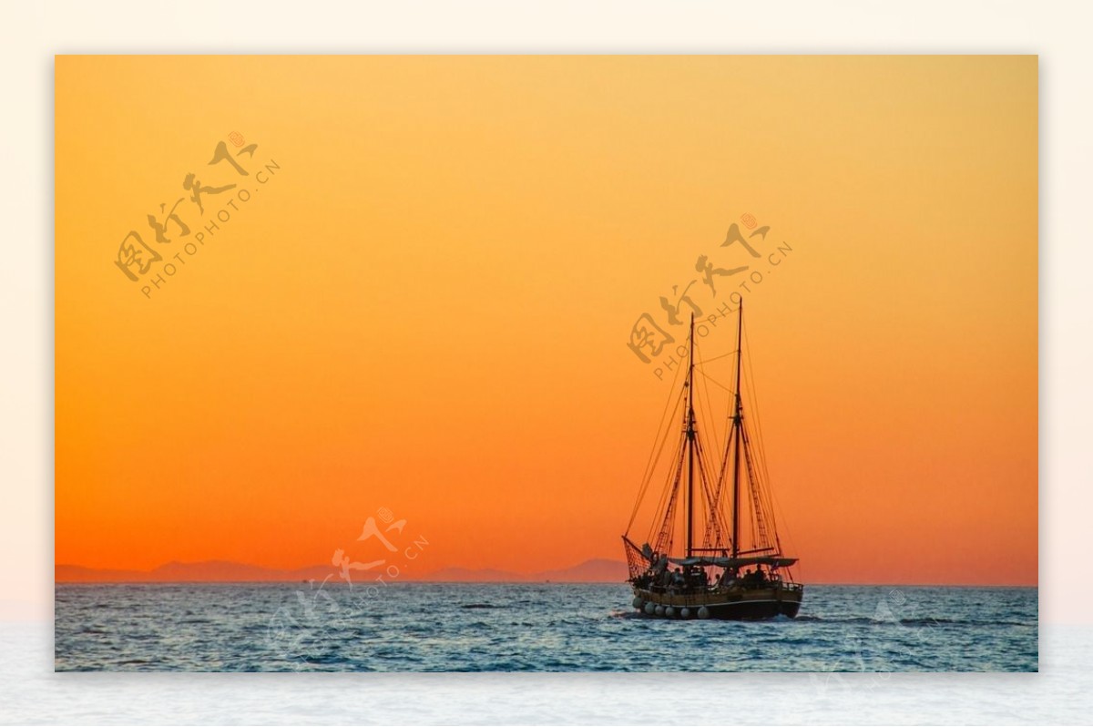 夕阳下大海上行驶的帆船