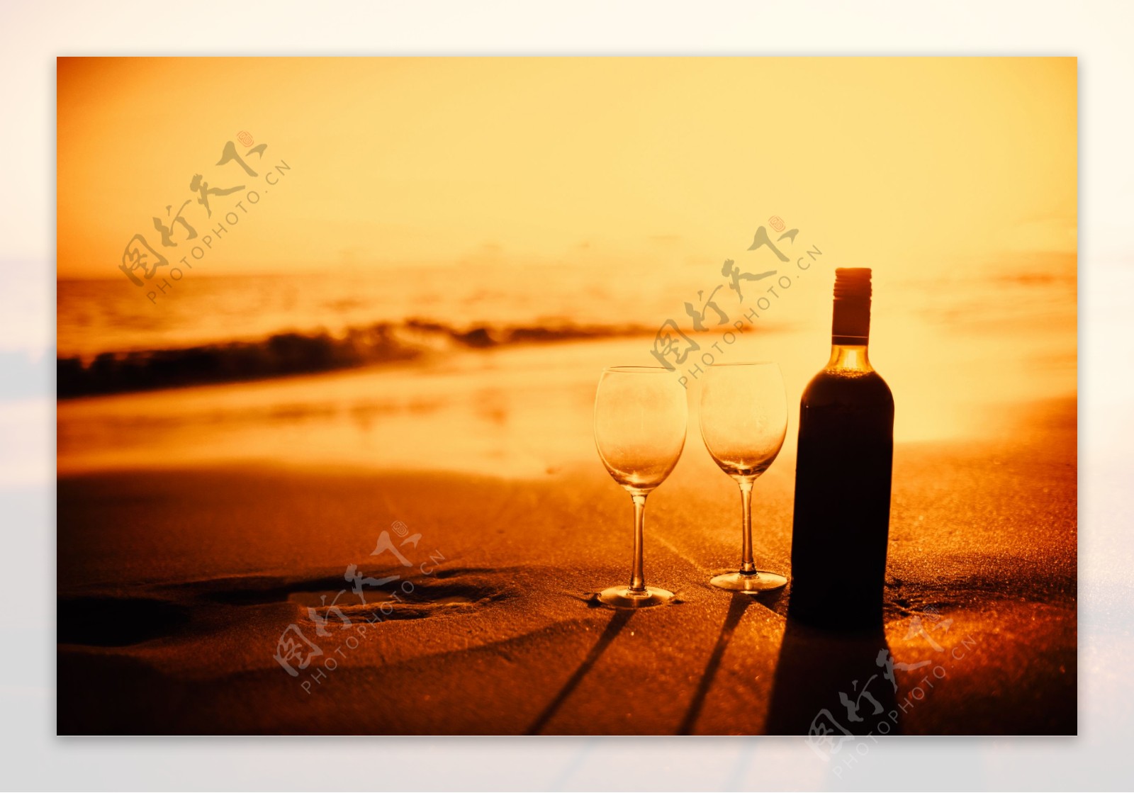 沙滩上有酒和酒杯图片