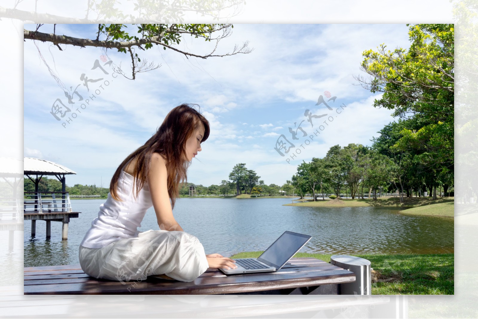 湖边玩电脑的女人图片