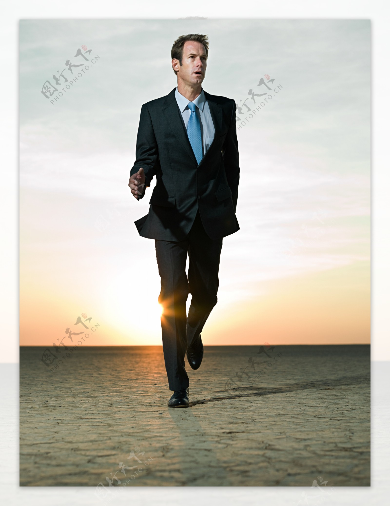沙漠中奔跑的外国商业男人图片
