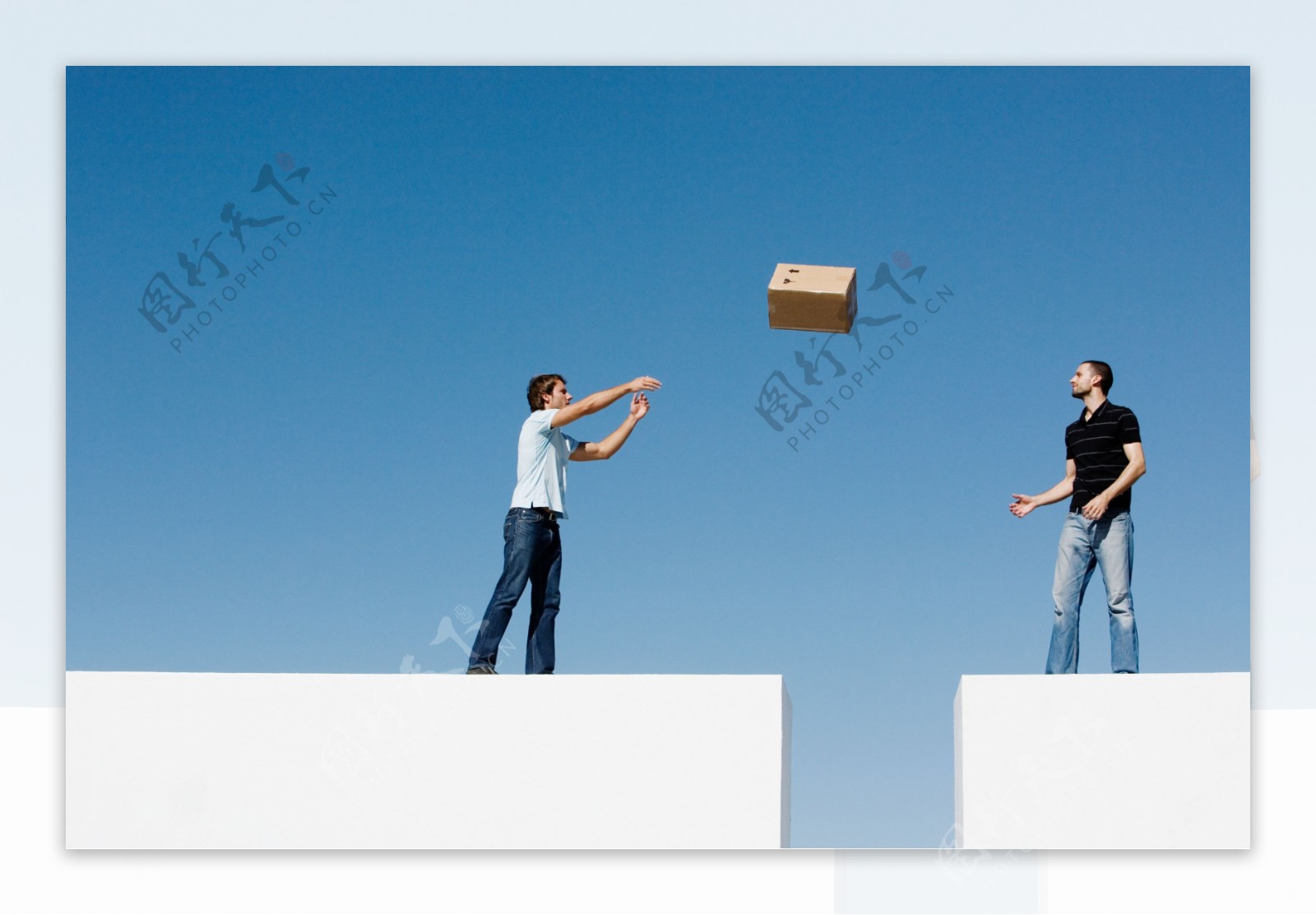 外国男人将纸箱抛给另一个人图片