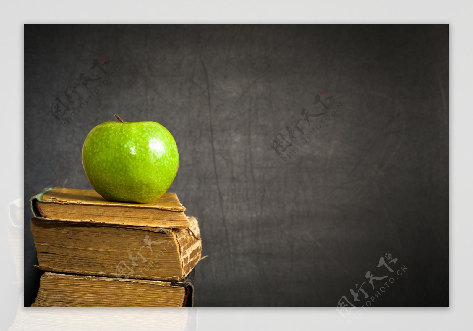 书本上的苹果和黑板背景图片