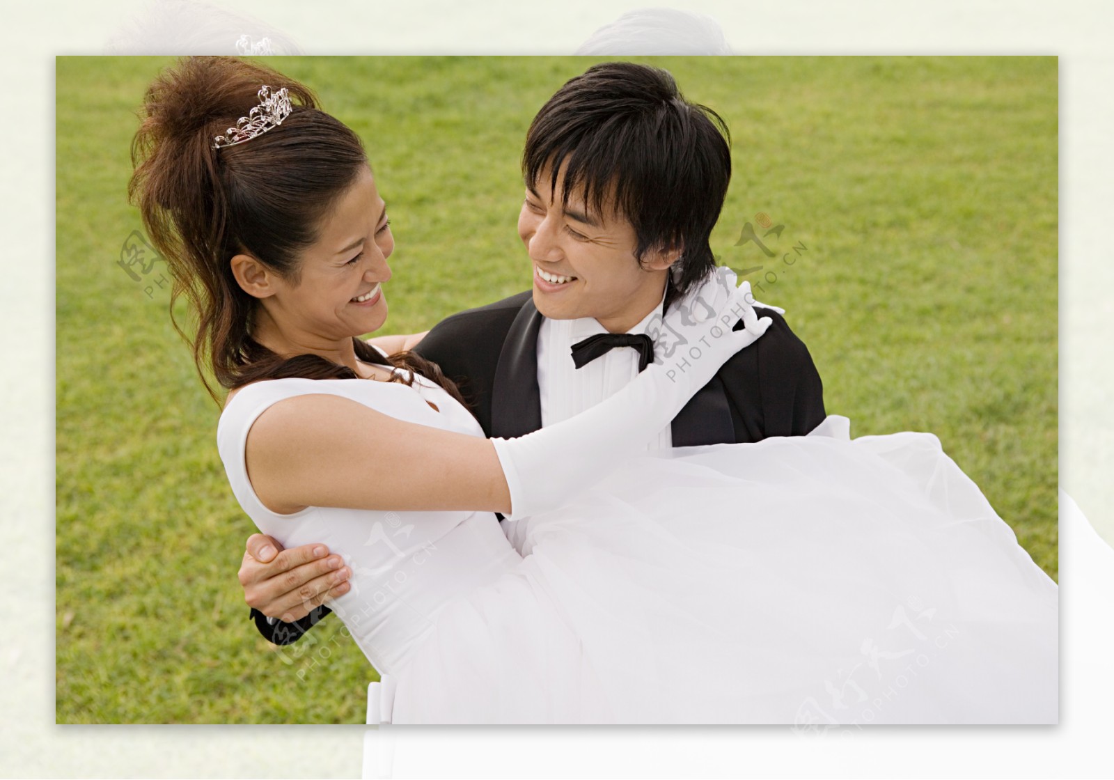 草坪上新郎抱着新娘幸福微笑图片