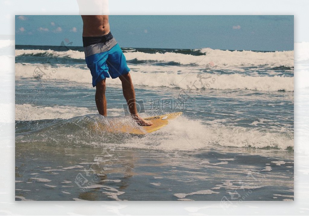 男人穿着蓝色和白色沙滩裤虽然冲浪