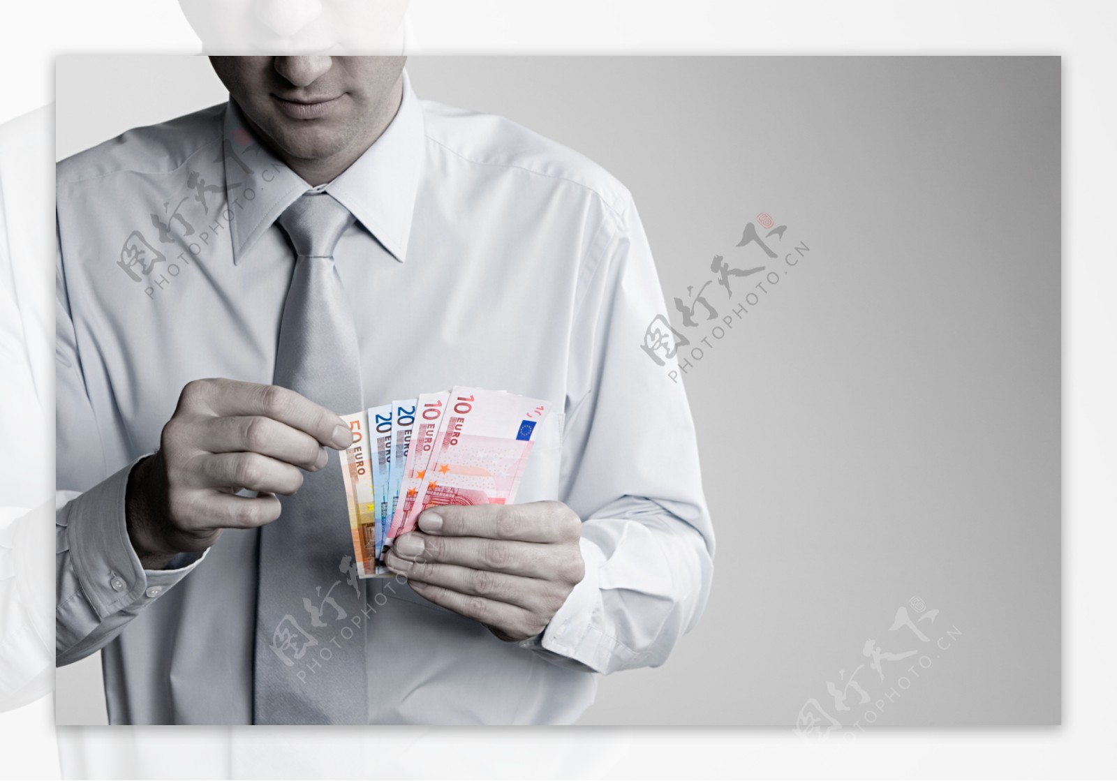 男人手里握着彩色的钞票图片