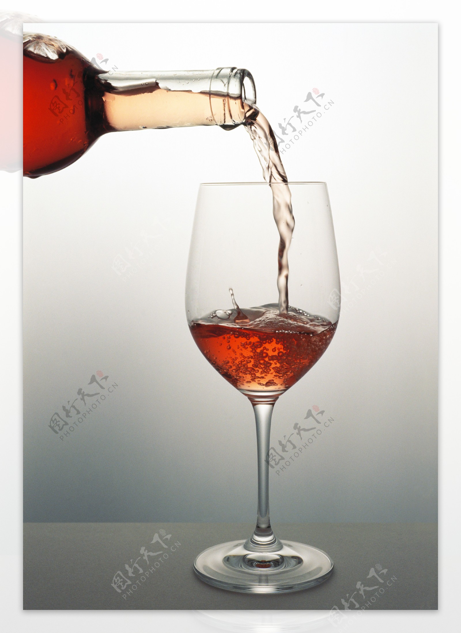 往杯里倒红酒时摄影图片