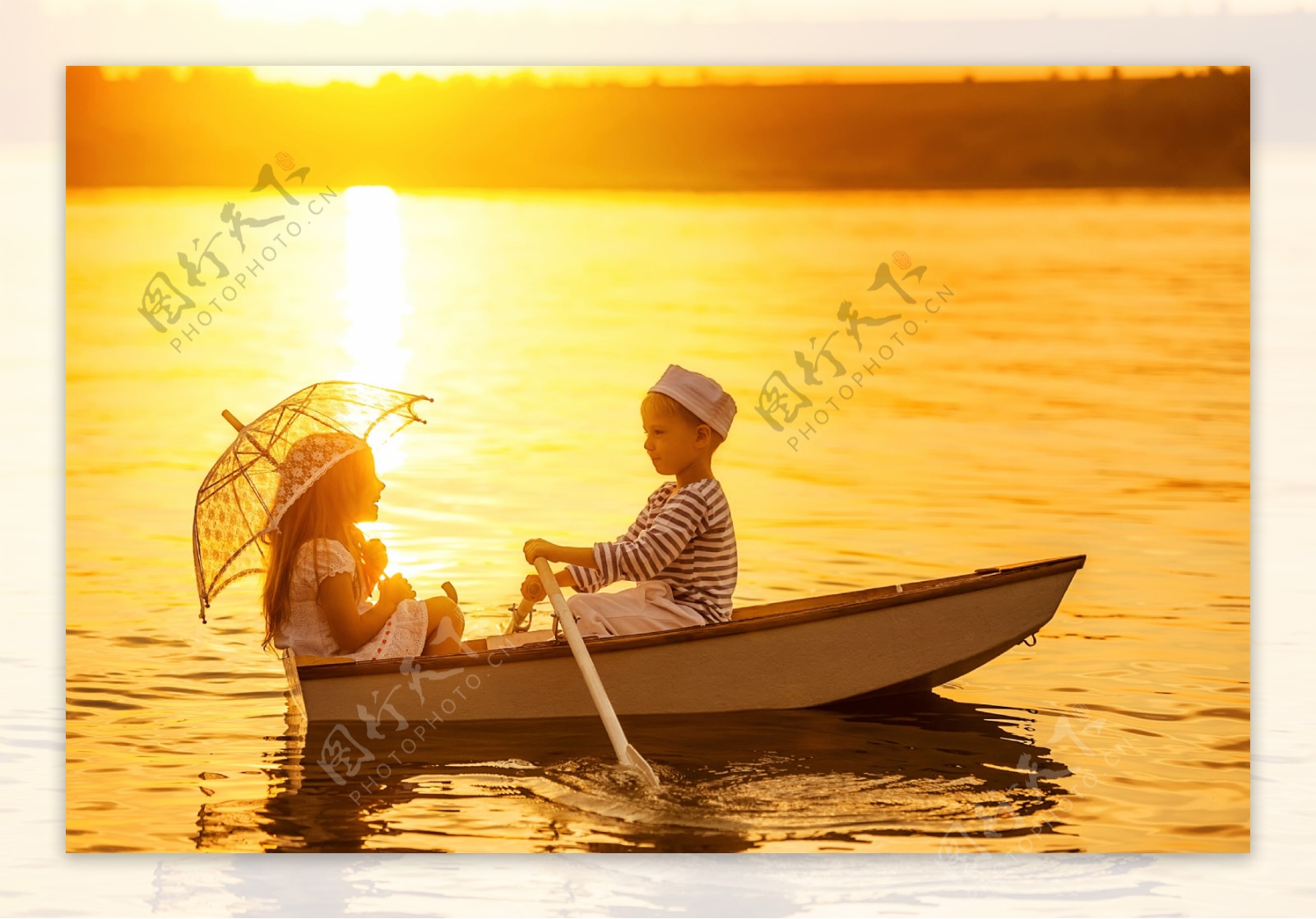 夕阳下正在划船的男孩女孩图片
