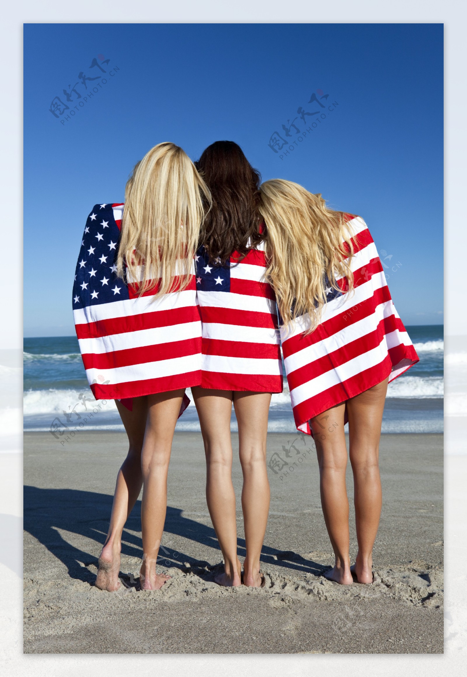 沙滩上披着国旗站着的外国美女背影