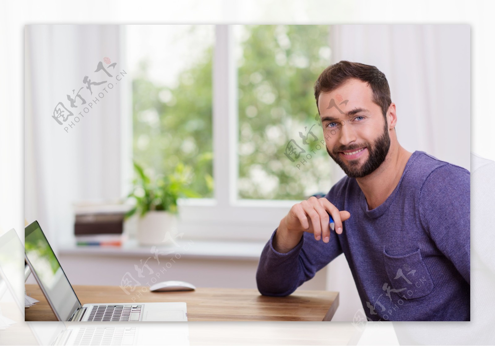 坐在电脑旁的胡子男图片