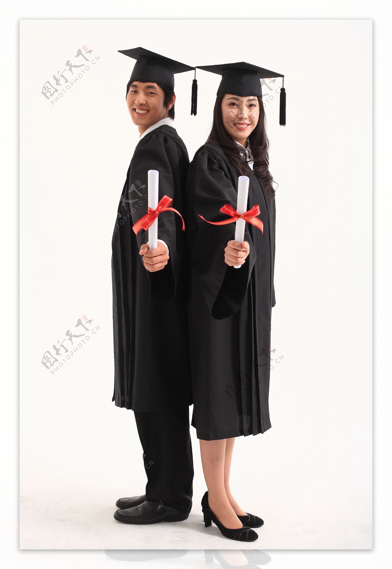 戴着博士帽拿着证书背靠背的情侣图片图片
