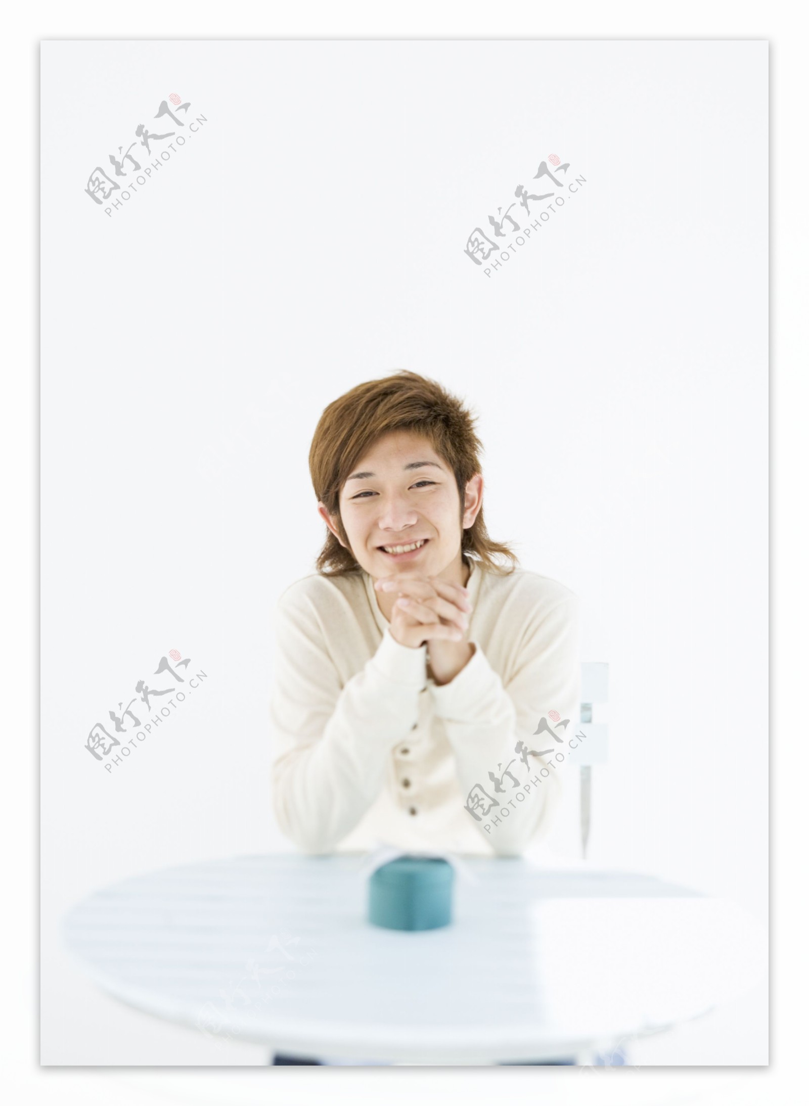 坐在桌子旁边的微笑男生图片