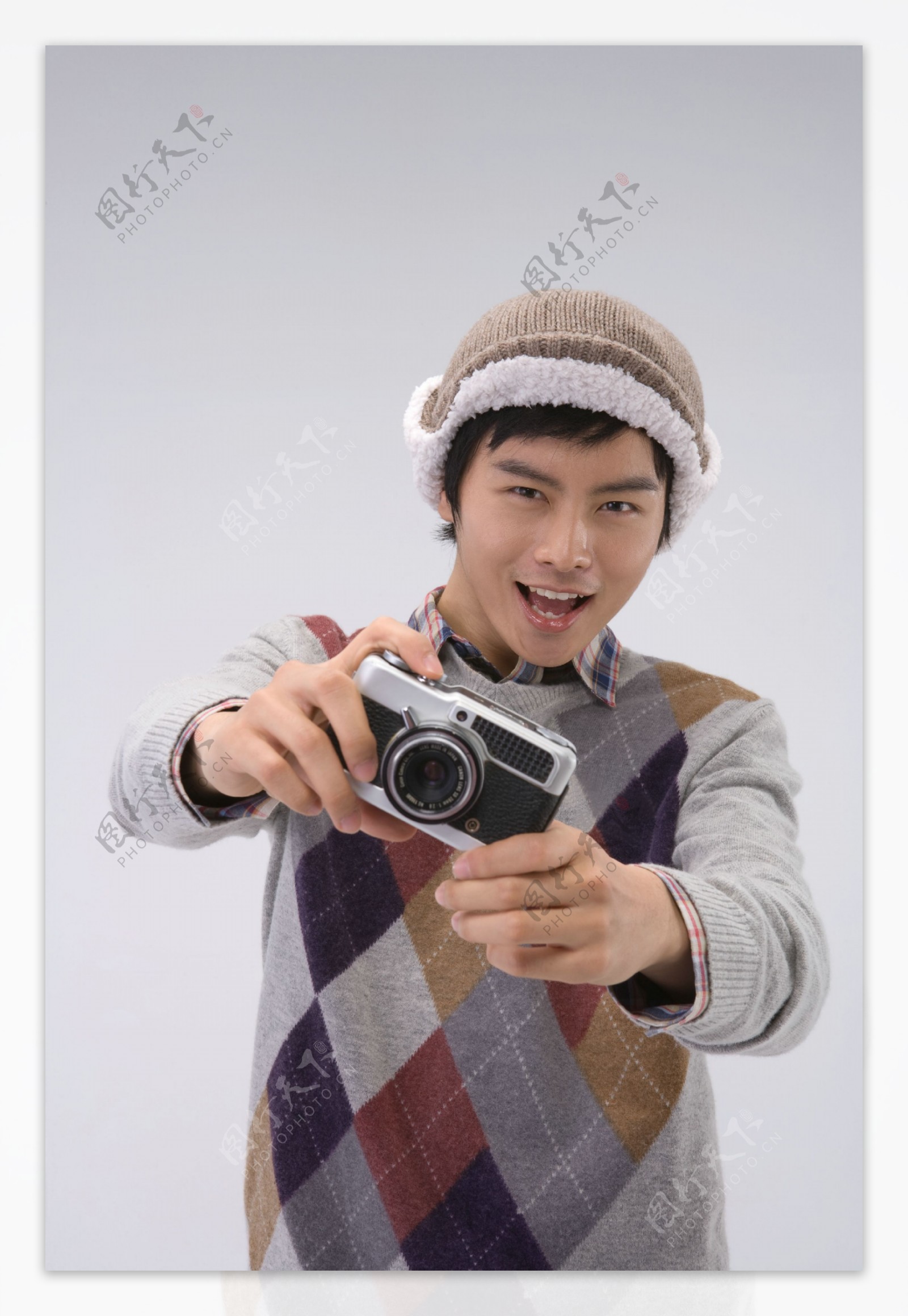 戴帽子拿着相机的开心男生图片